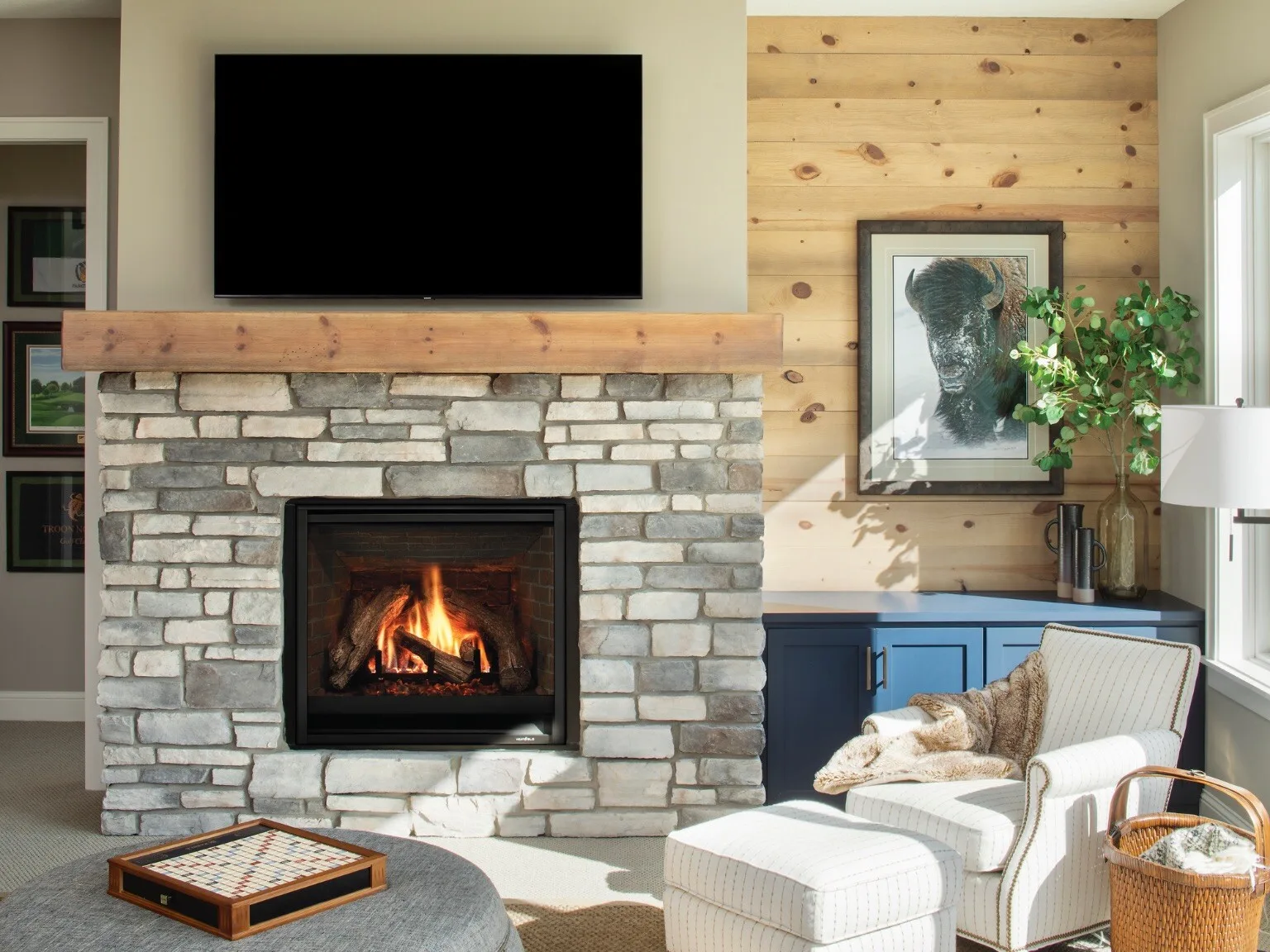 Gas fireplace in a stone surround with a wood mantel