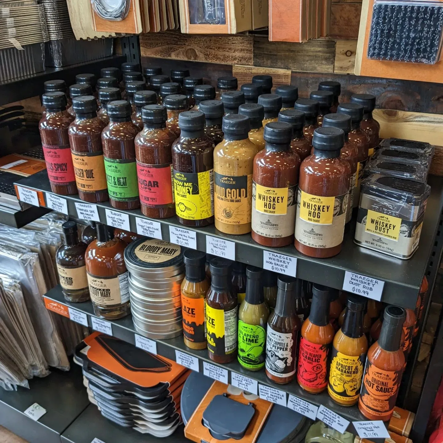 Shelves of Traeger rubs, sauces, and hot sauces on the showroom spice wall