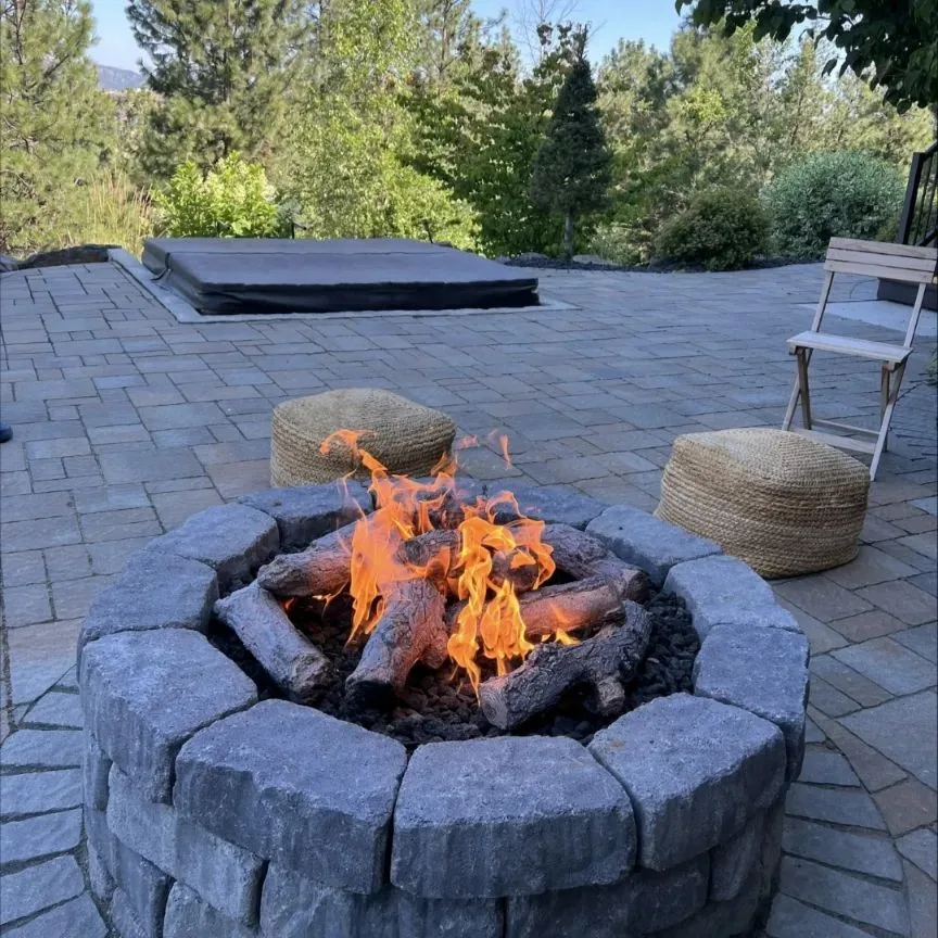 Stone gas fire pit on a paver patio