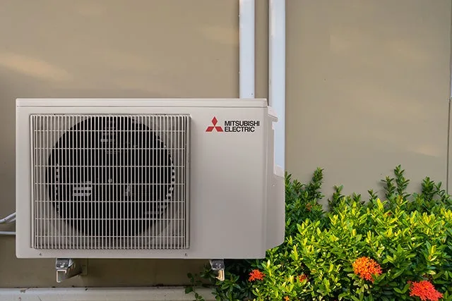 Mitsubishi ductless outdoor unit beside a home's entry