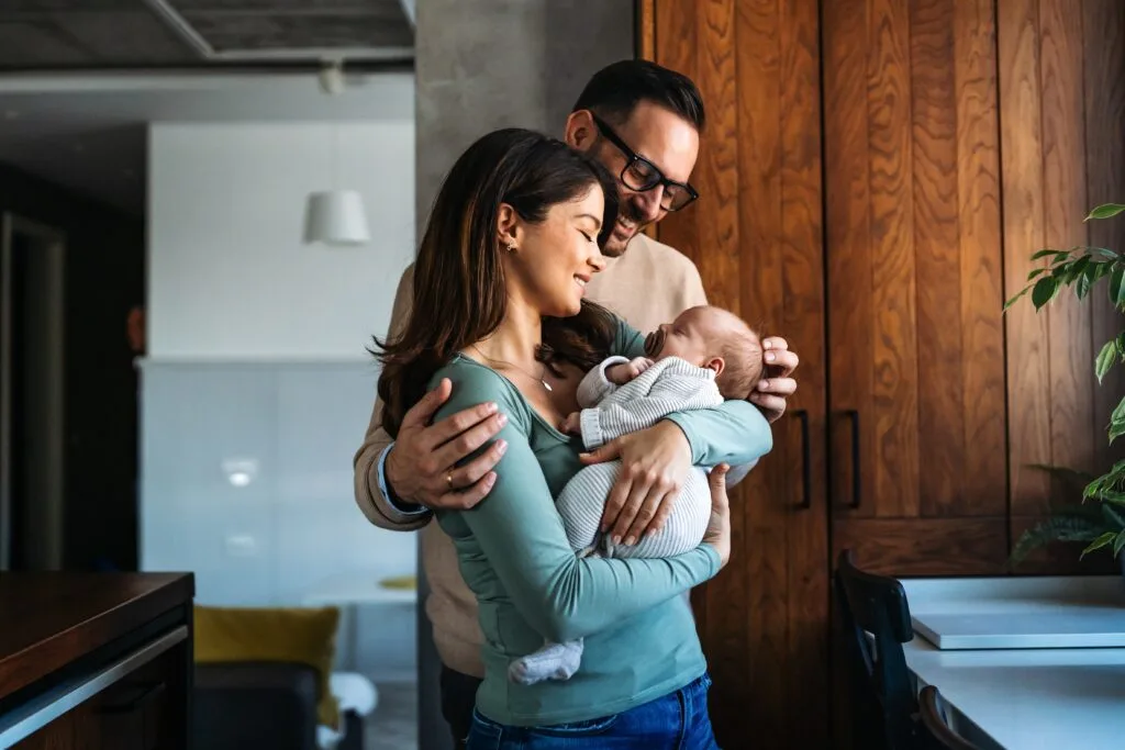 Mother holding her baby in a bright, comfortable living room