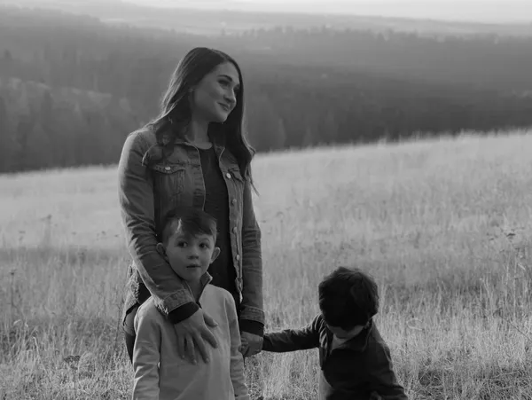 Andrea Falco outdoors with two young children