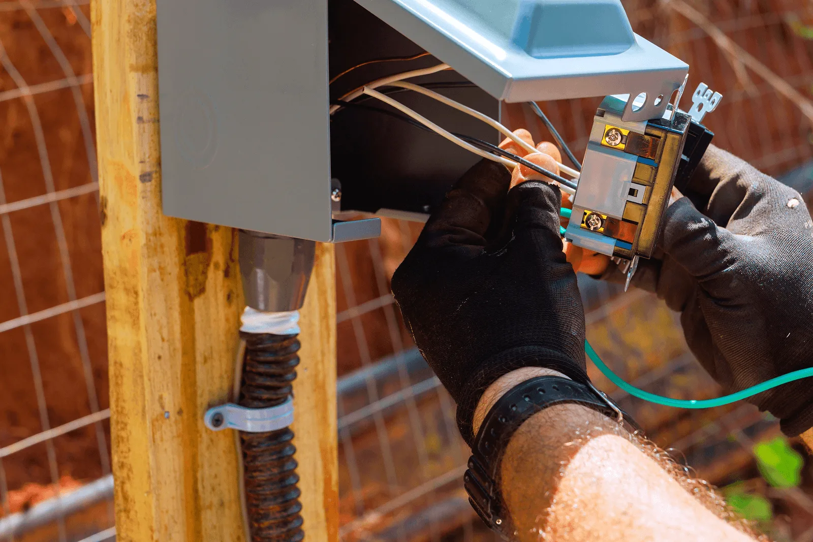 An electrician wiring an outdoor receptacle box