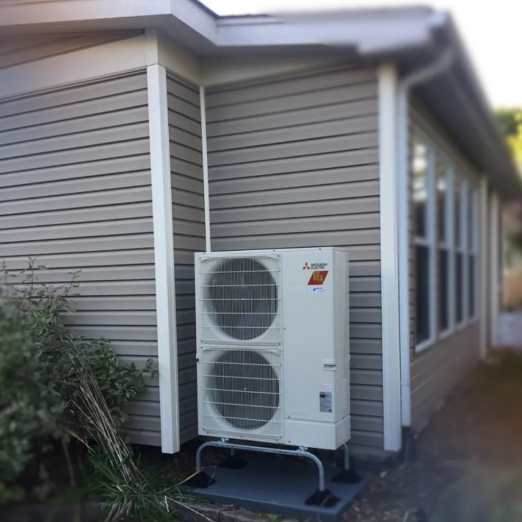 Mitsubishi outdoor unit beside a new home